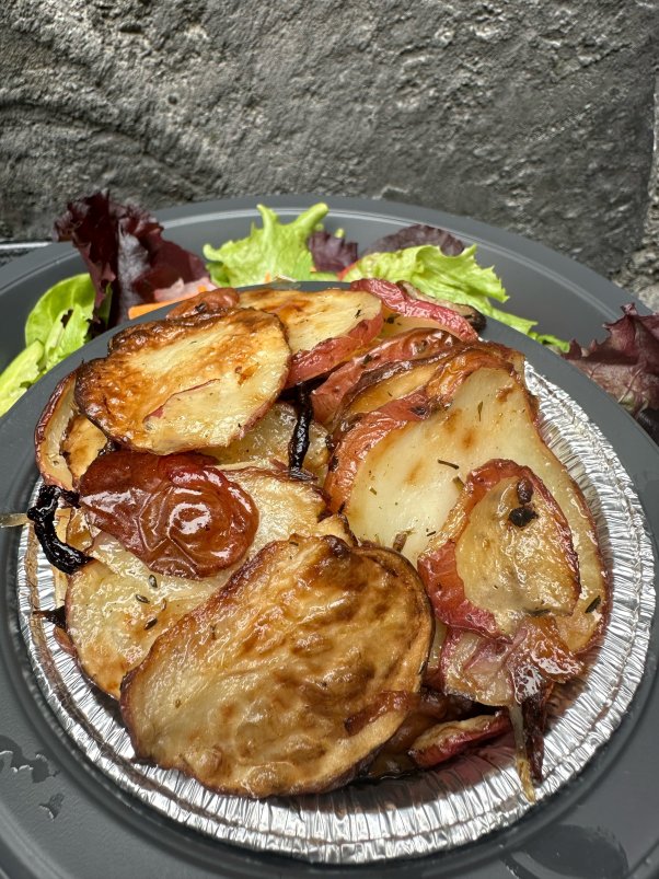 vegan shepherd's pie with sliced roasted potatoes on top and a side salad behind it; from three broomstick's at universal studios hollywood