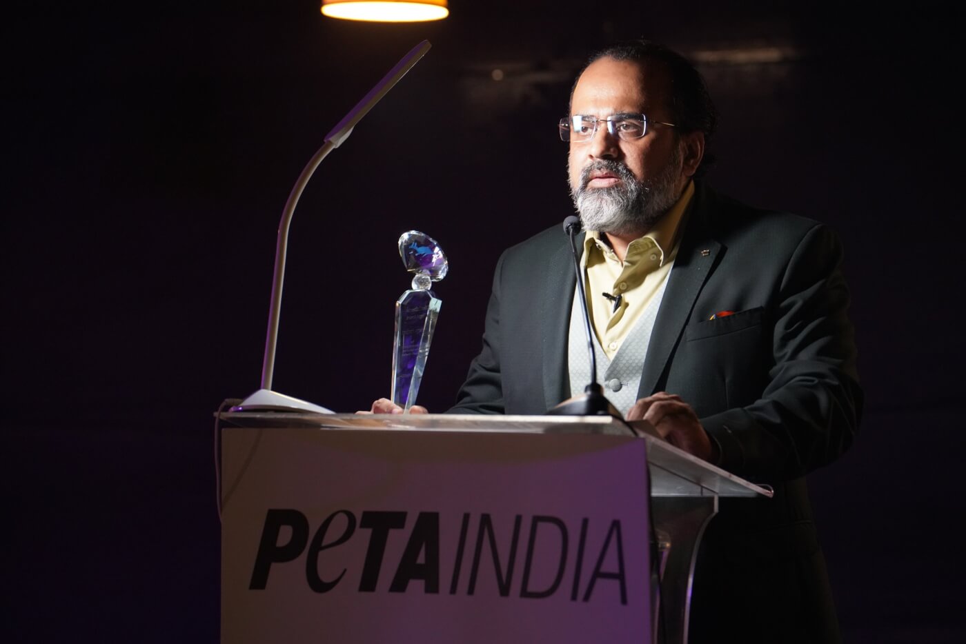 Acharya Prashant with award at podium scaled Most Influential Vegan in India Talks With Ingrid Newkirk