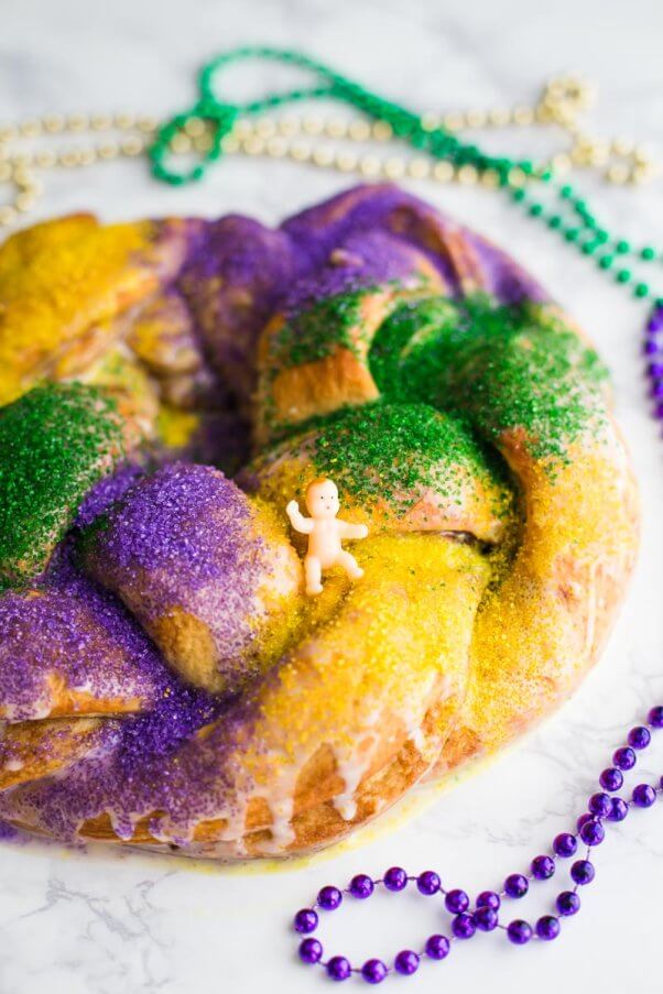 vegan king cake with tiny baby and red purple and gold beads