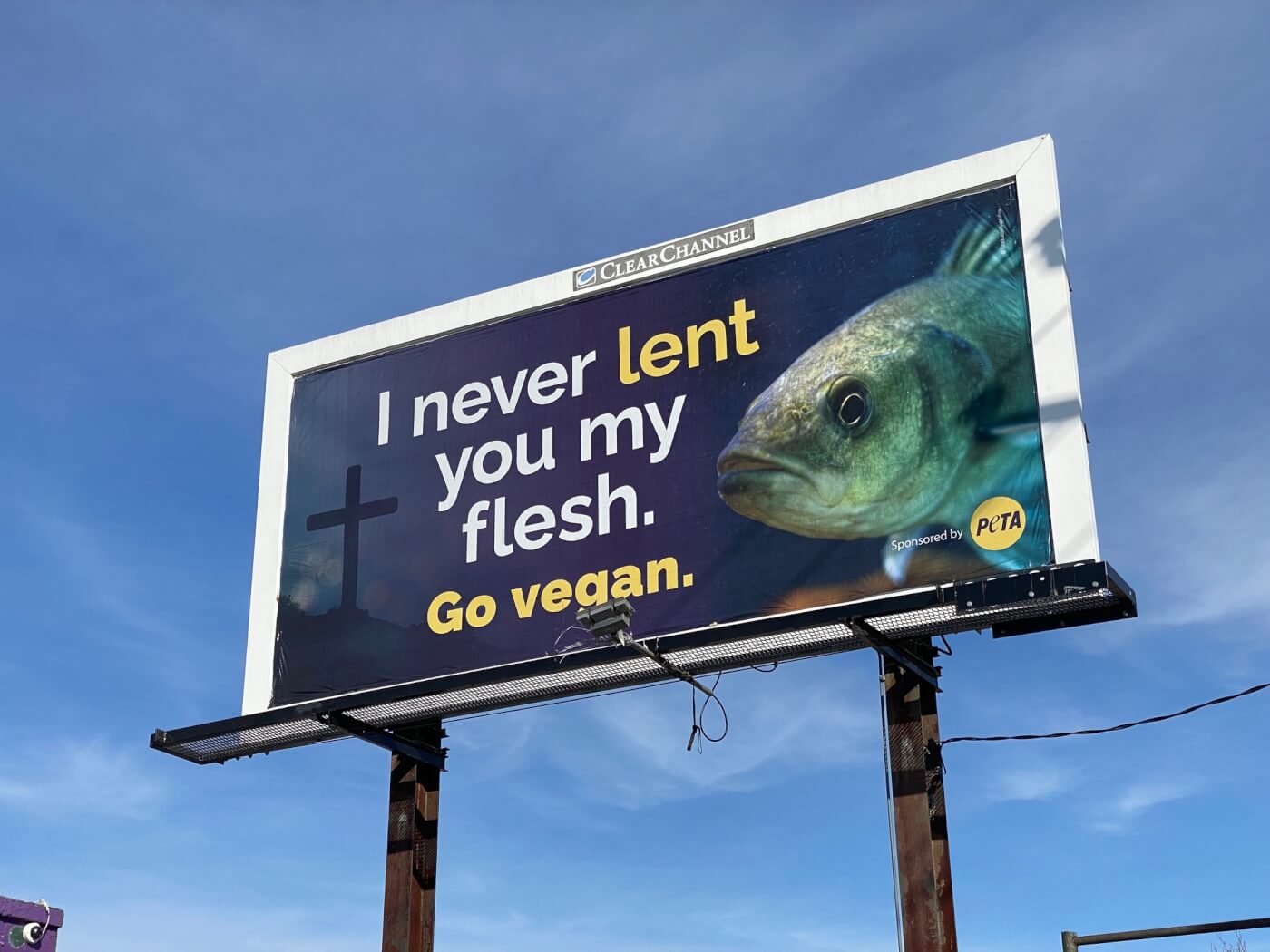 Fish billboard with cross in the background and text that says "I never lent you my flesh. Go Vegan"