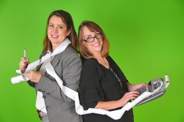 Amber and Kelly wrapped up in receipts with green background