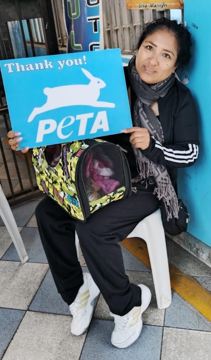 A woman at PETA's Spay-a-Thon in Peru with a sign that says "Thank you! PETA"