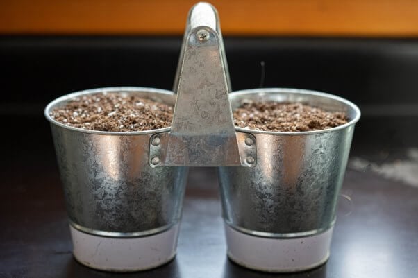 two planter pots with soil inside