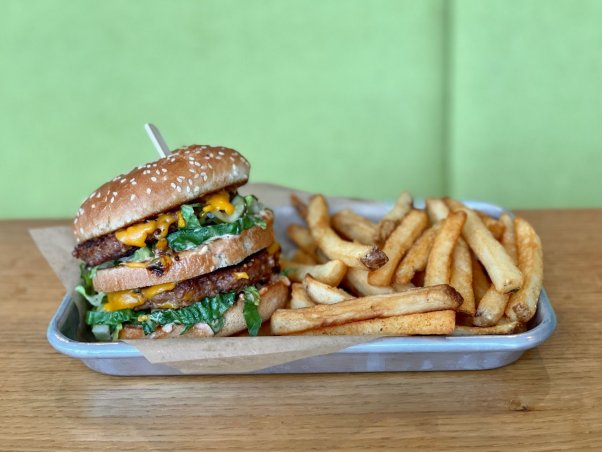 J Selby's Dirty Secret burger, a Big Mac-inspired vegan burger next to a side of fries