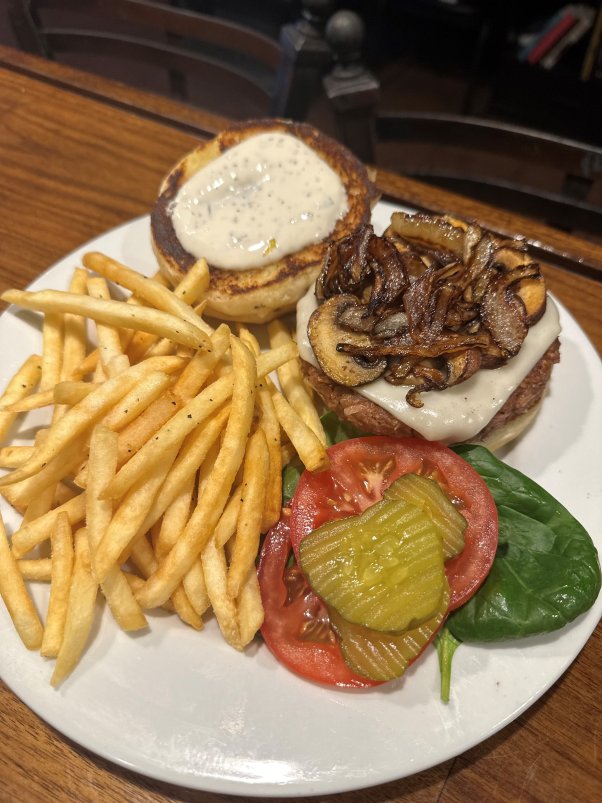 Mark of the Beastro burger with grilled mushrooms on a plate with a side of fries