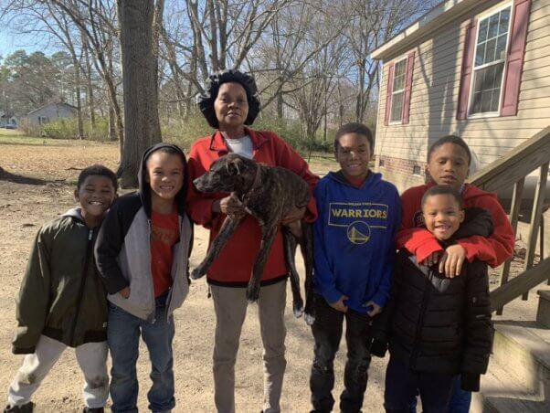 dog neutered by PETA poses with his human guardians