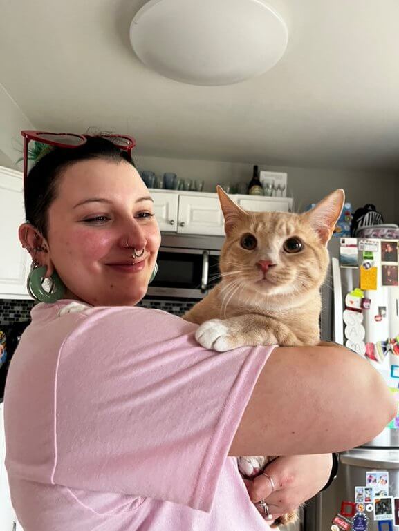 happy cat poses with human guardian