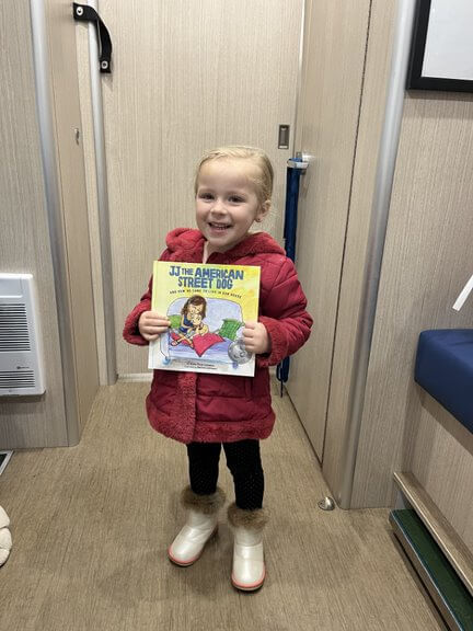 child holding book she received from PETA