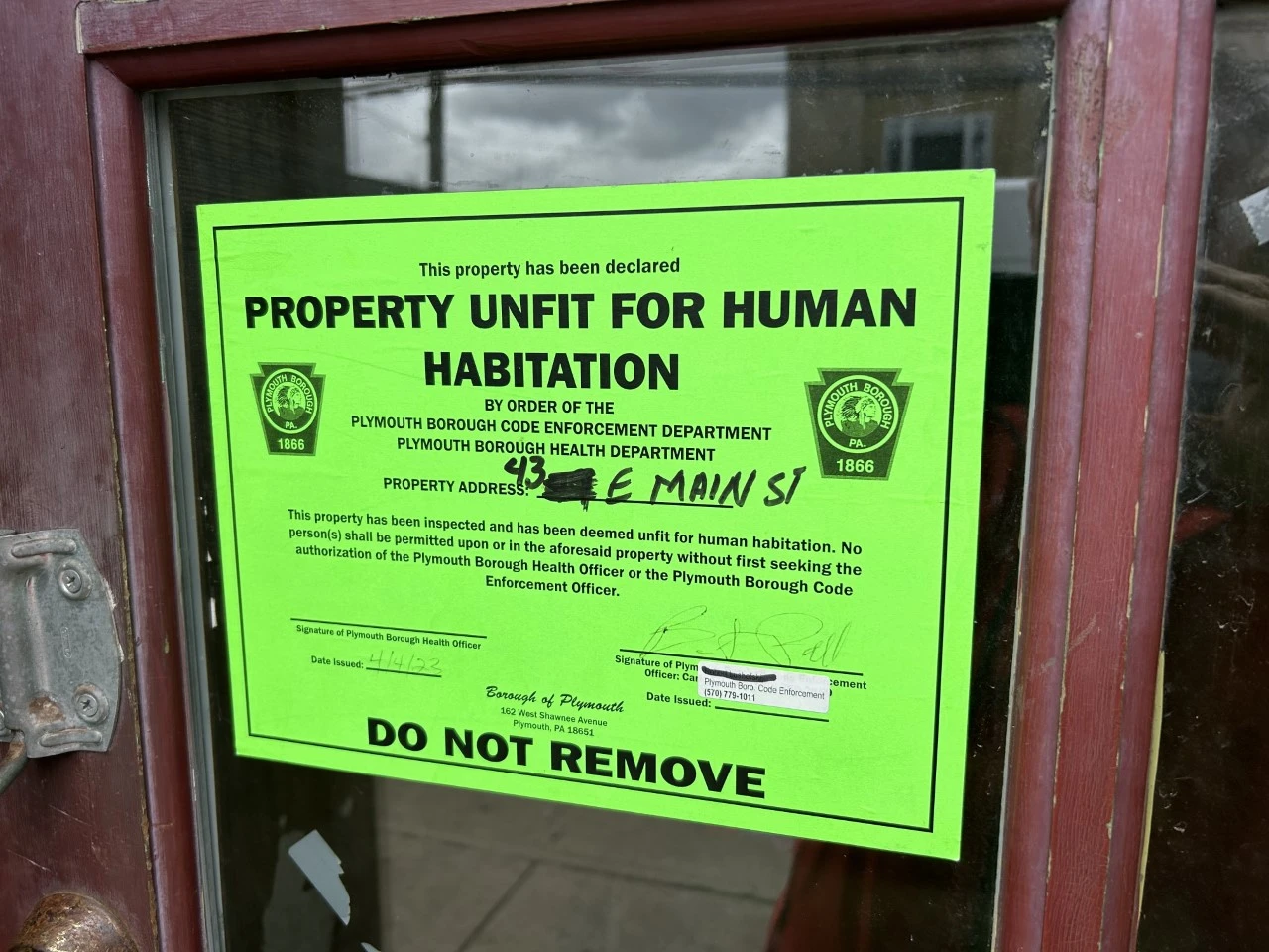 a sign on the front door of a closed, condemned reptile store in Plymouth, Pennsylvania, that reads "Property Unfit for Human Habitation"
