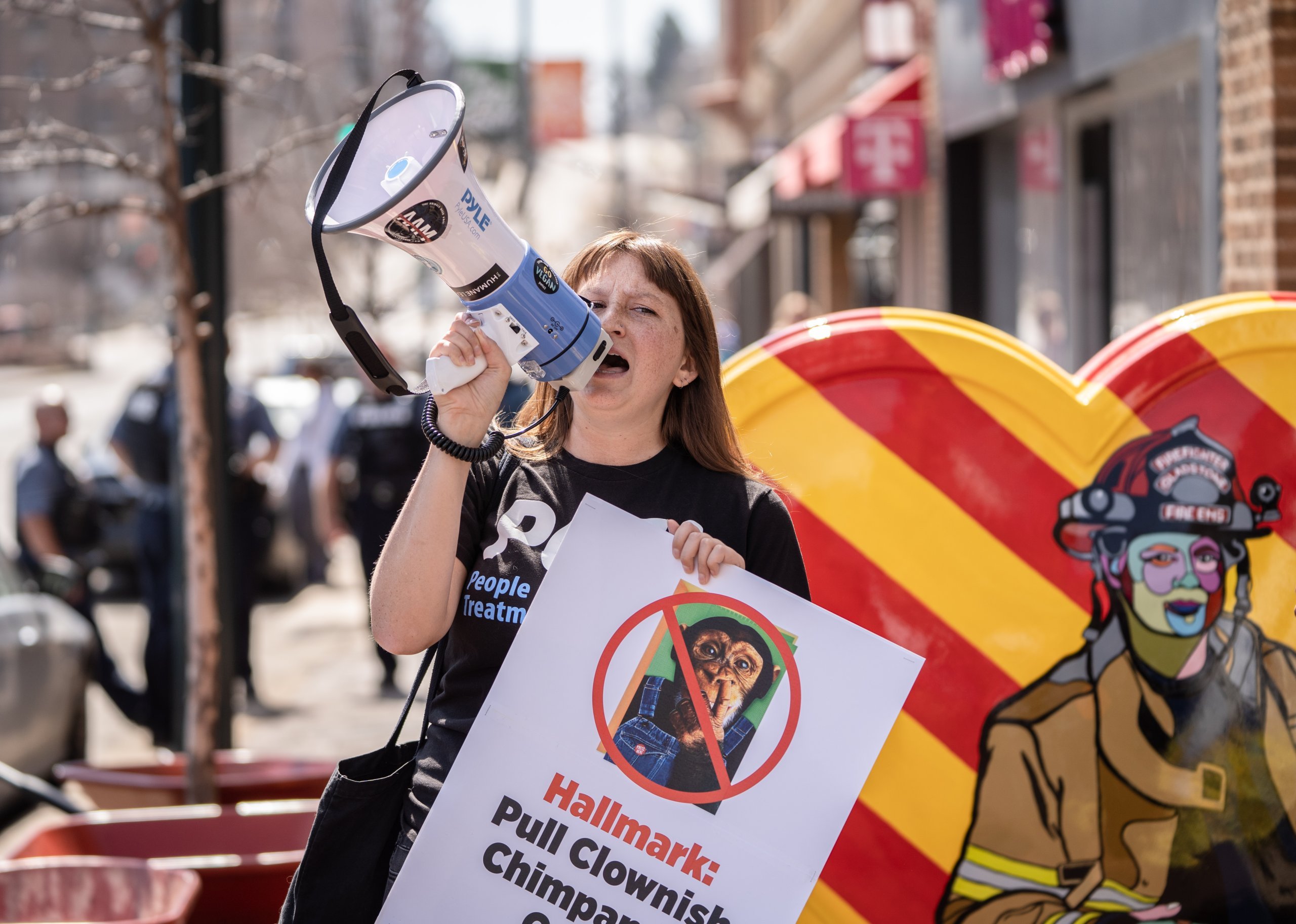 Person holding a megaphone and holding a protest sign