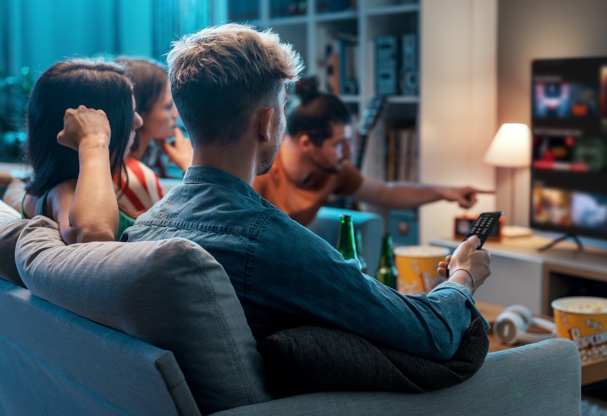 Group of people sitting on a couch and watching TV