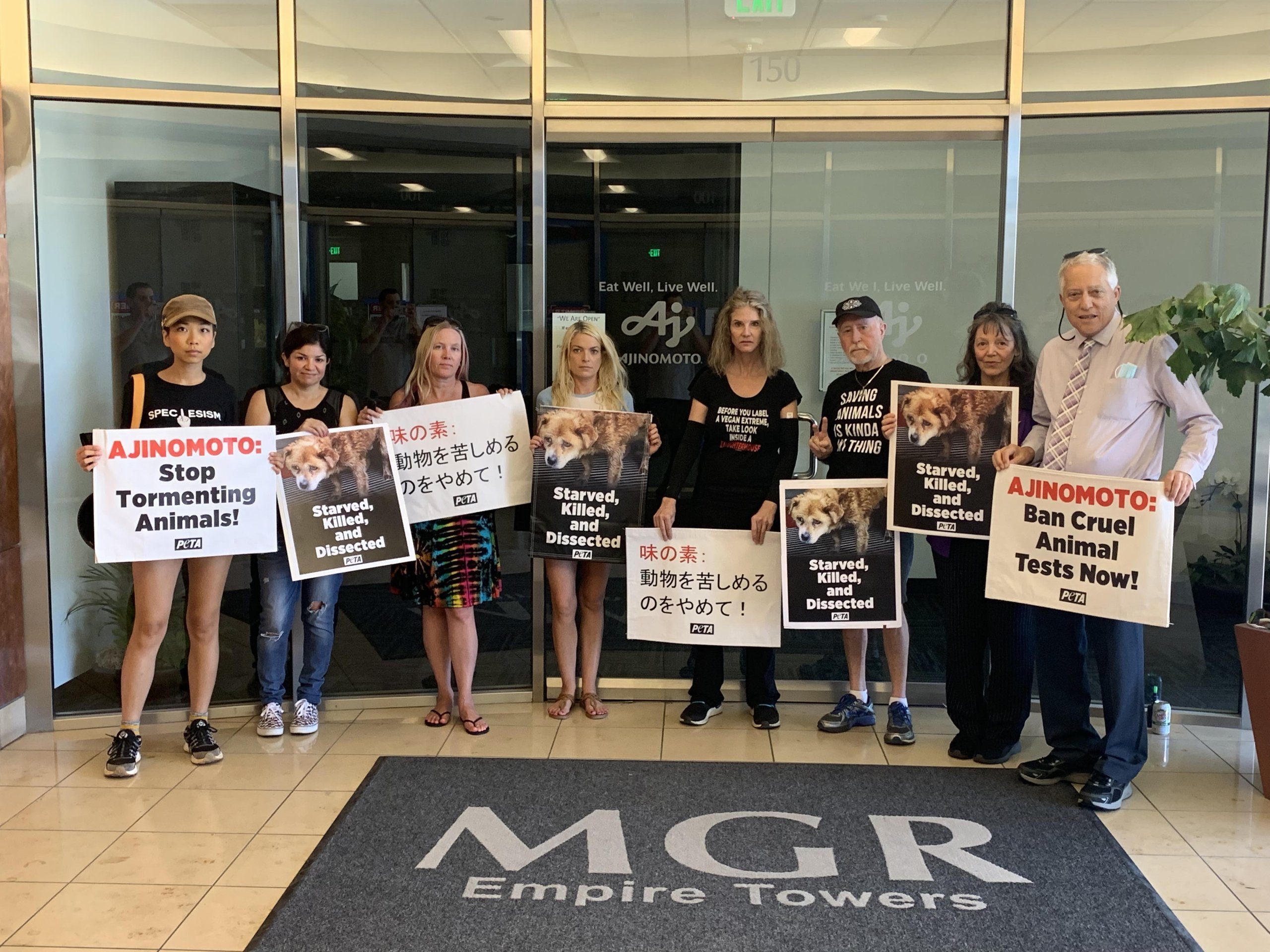 Group of eight PETA supporters standing in a row with signs