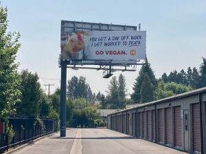 Billboard in Salem, OR featuring a hen with text that reads you get a day off work, I get worked to death. Go vegan