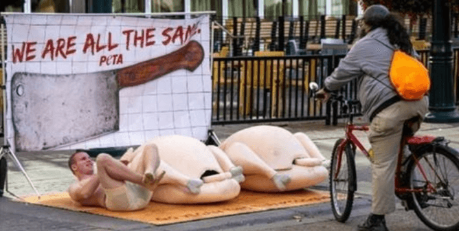 peta supporter on a human-sized "plate" in the street protesting the consumption of turkeys for thanksgiving