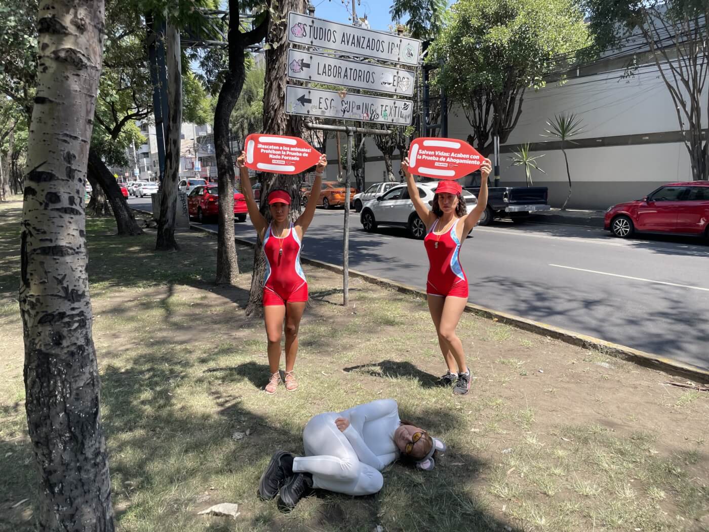 two people dressed as lifeguards hold floats and