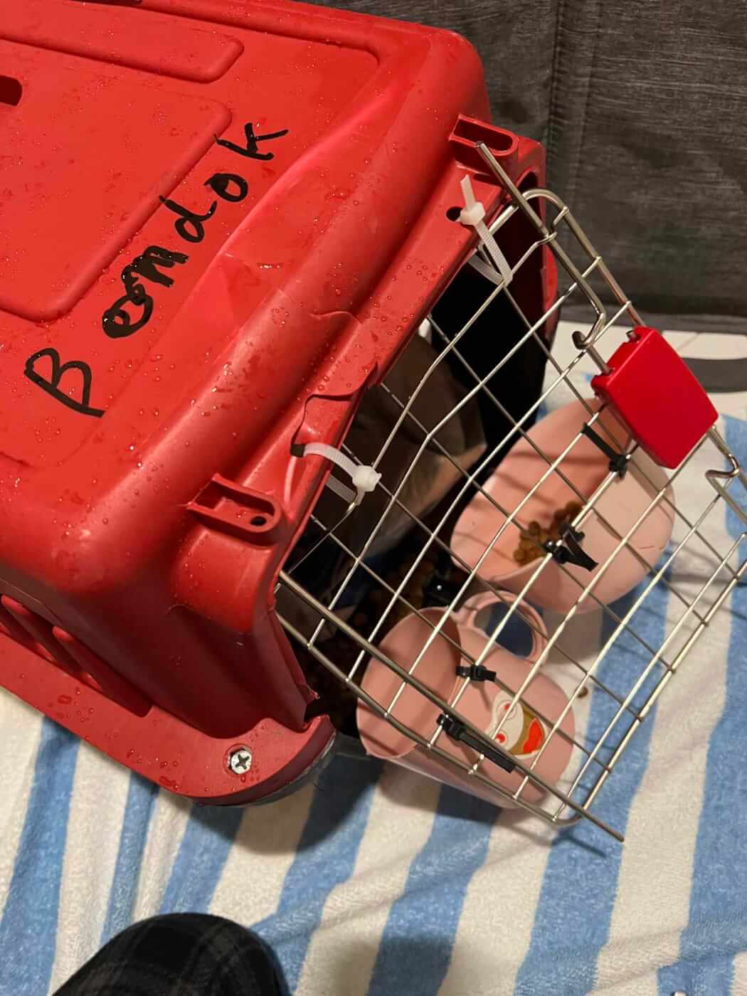 A broken red crate with a door that cannot close