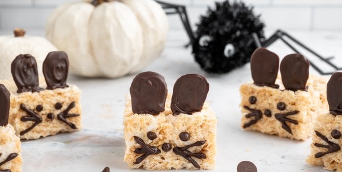 vegan rice crispie treats decorated to look like mice with a Halloween-themed backdrop