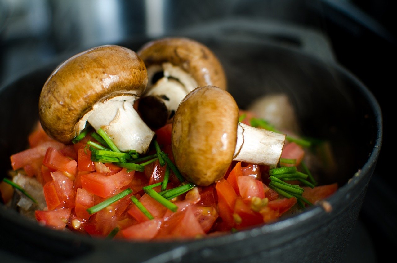 Button mushrooms on a bed of chives and diced tomatoes