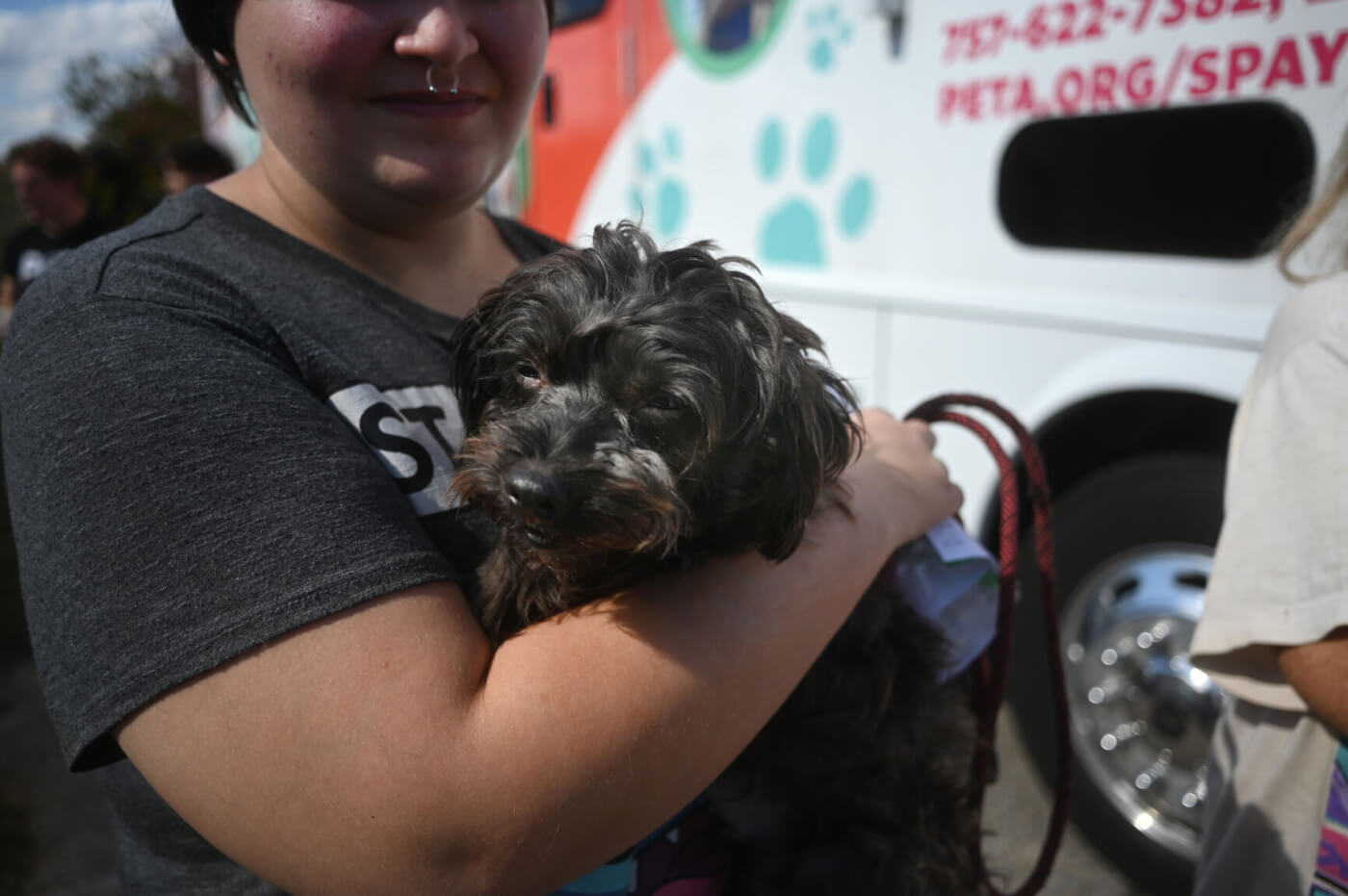guardian holding a black fluffy dog at Danville mobile spay/neuter clinic