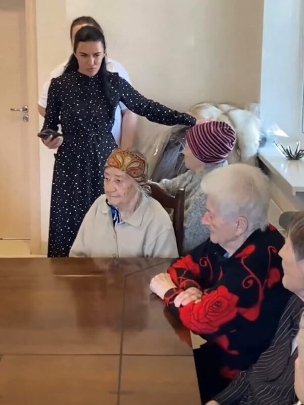 teams supported by PETA donating fur coats to Ukraine, showing older people at a table who are waiting to try on a coat