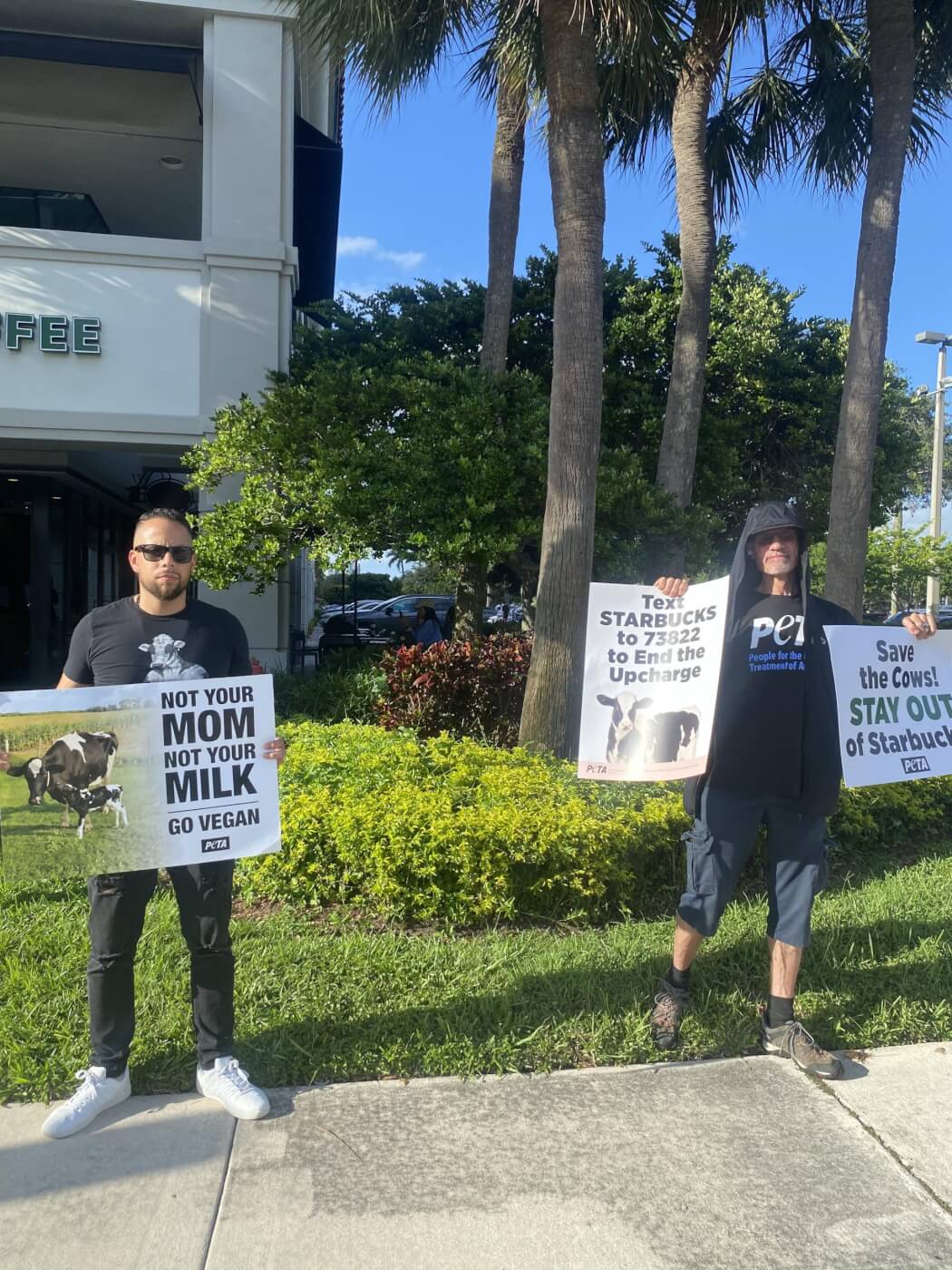 protestors outside a Starbucks hold signs