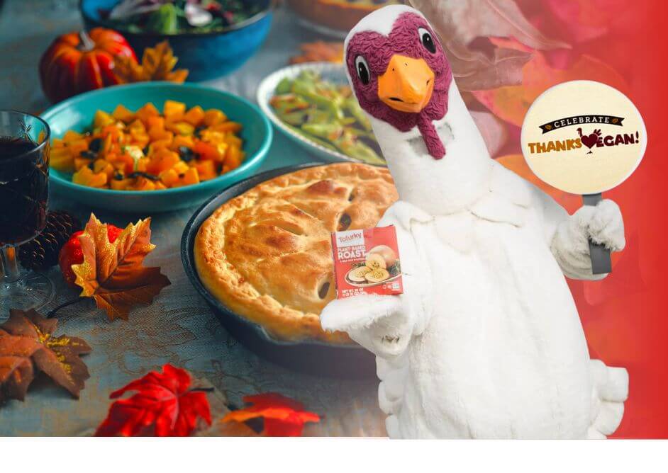 vegan thanksgiving food like squash, pie, and snap peas and turkey mascot holding "celebrate thanksvegan" sign