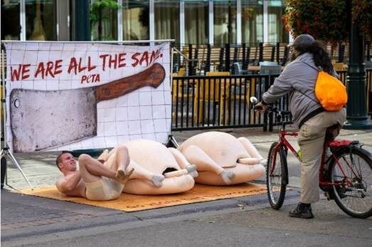 peta supporter on a human-sized "plate" in the street protesting the consumption of turkeys for thanksgiving