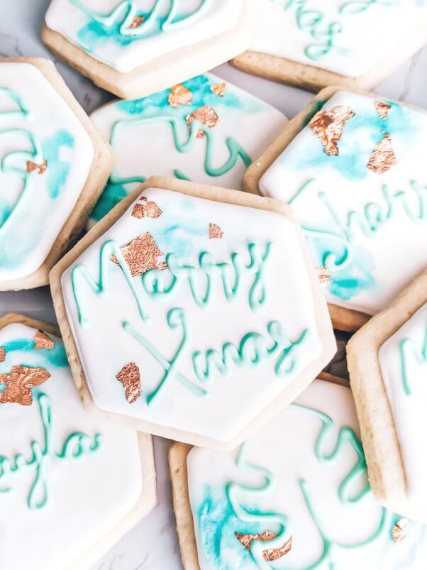 a pile of vegan sugar cookies decorated with "merry xmas"