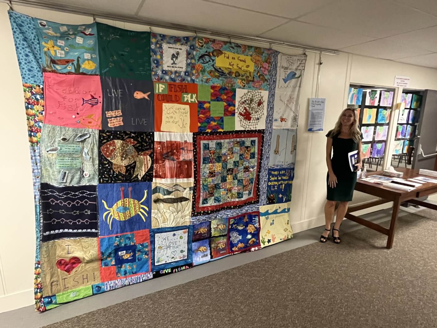 PETA Staffer Ashley stands next to the fish empathy quilt