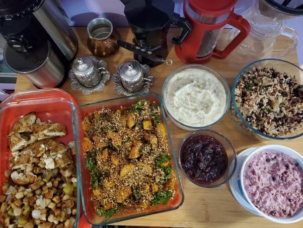 table with various thanksvegan dishes, including a stuffed tofu turkey and a squash dish