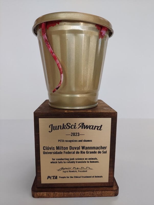 Photo of the JunkSci award trophy, featuring a golden garbage can with a blood stained rim