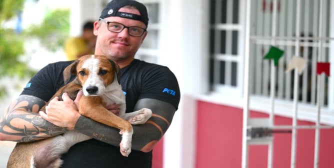 Photo of PETA volunteer holding a beagle