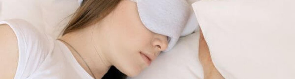 woman sleeping in a bed with an eye mask on