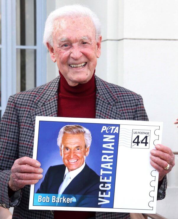 Bob Barker holding a PETA stamp with his photo on it