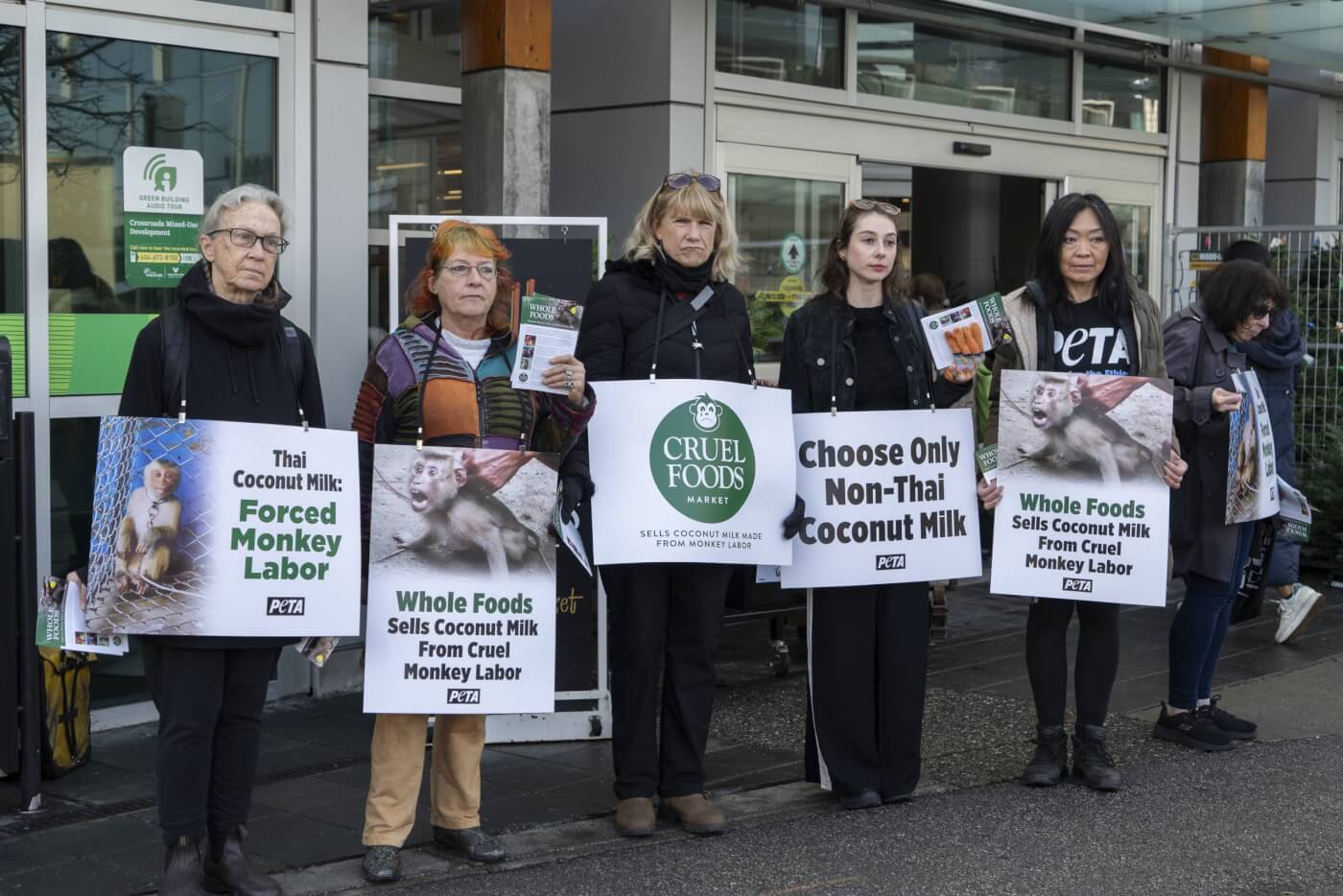 a line of six PETA supporters doing a peaceful demonstration at a Whole Foods store in Vancouver, protesting coconut milk from Thailand