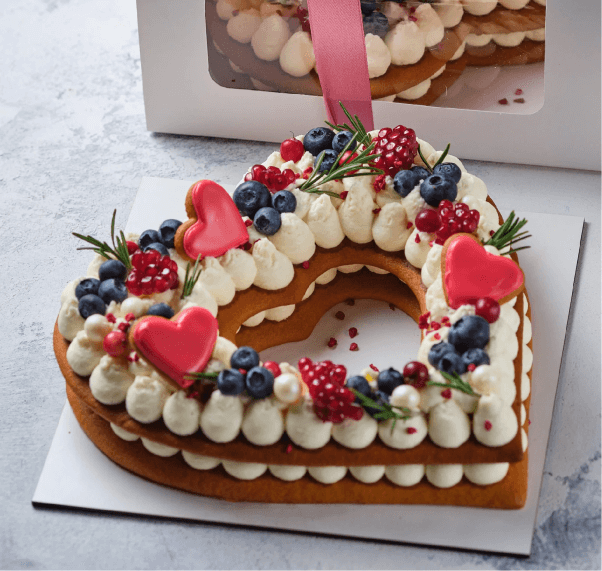 vegan heart-shaped tart cake from Giselle's Vegan Kitchen, covered in fruit and macarons