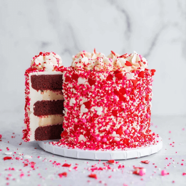 a vegan ralentine's day themed red velvet cake covered in sprinkles, from Karma Baker