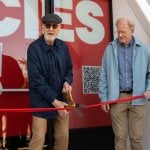 Photo of James Cromwell cutting red ribbon