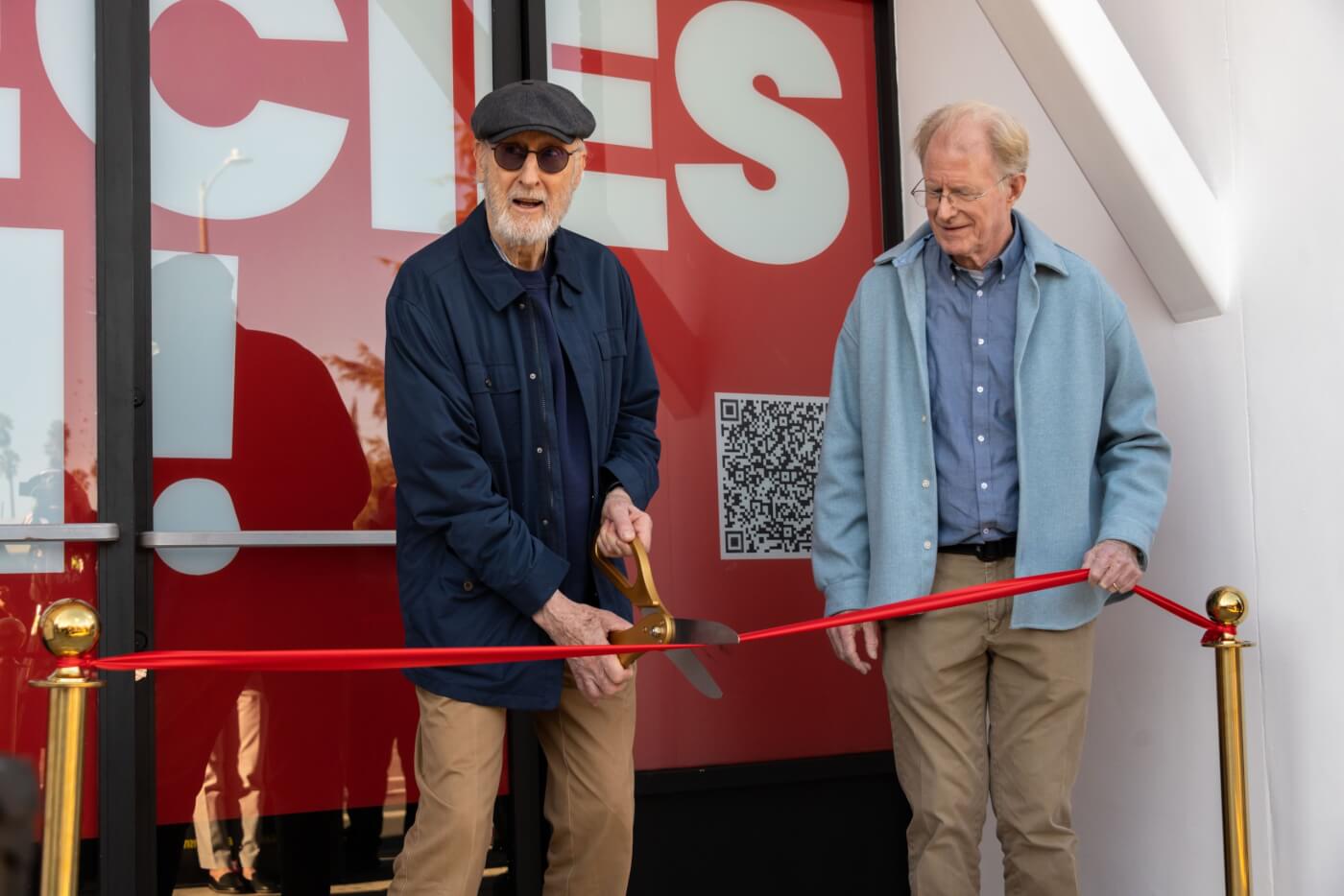 Photo of James Cromwell cutting red ribbon