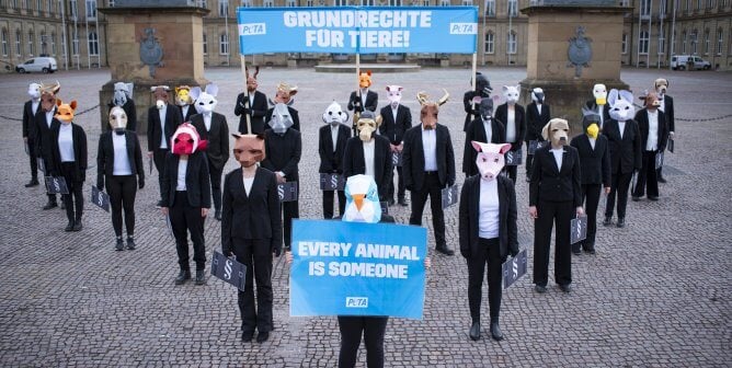 peta germany supporters in animal masks and businesswear in a triangle formation