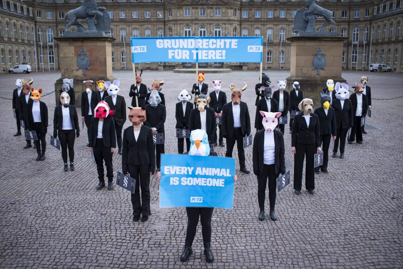 peta germany supporters in animal masks and businesswear in a triangle formation