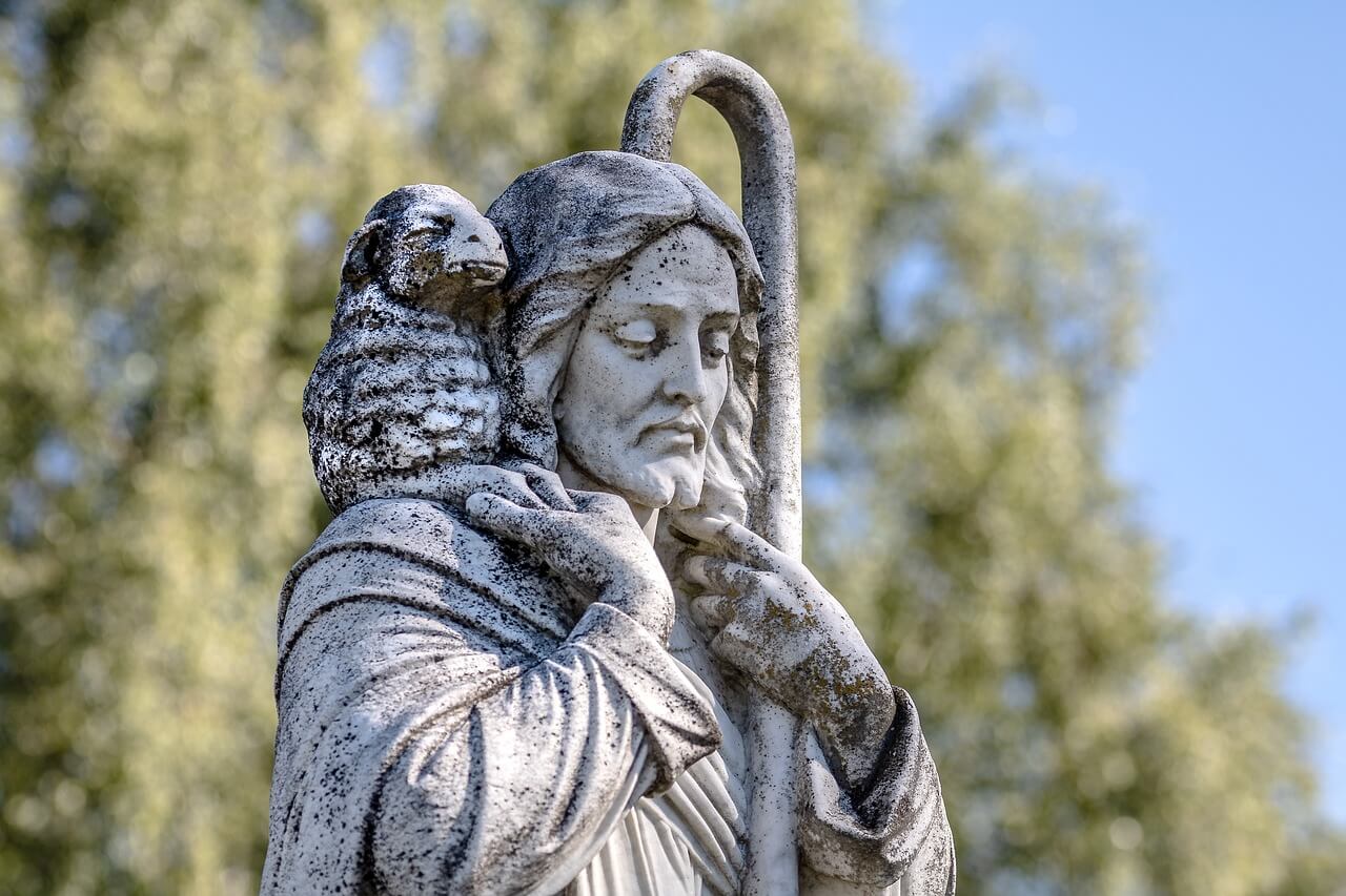 A statue of Jesus. He is holding a lamb over his shoulders
