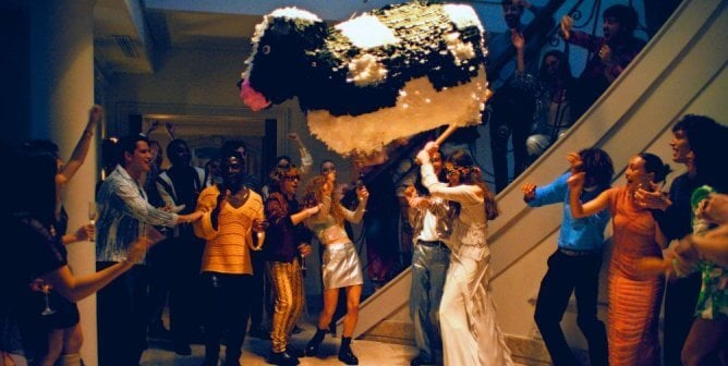 A person hitting a cow Piñata surrounded by cheering people, as a still from a video that PETA U.K. sent to the fashion brand of Victoria Beckham