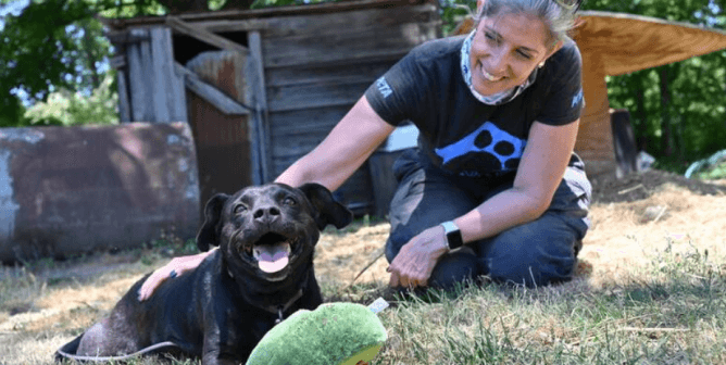 PETA CAP worker with Midnight, a black dog