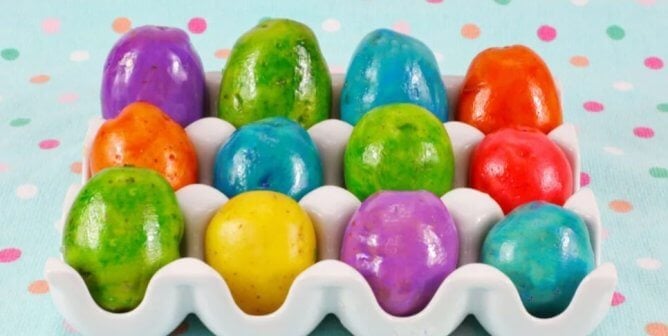 a variety of colorful dyed potatoes, similar to Easter eggs, displayed in a white tray