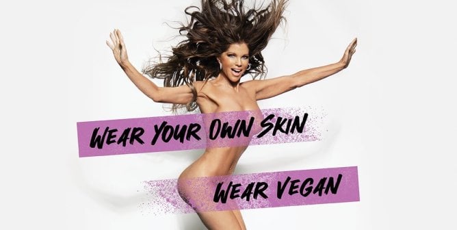 Donna D'errico posing with text reading Wear Your Own Skin. Wear Vegan