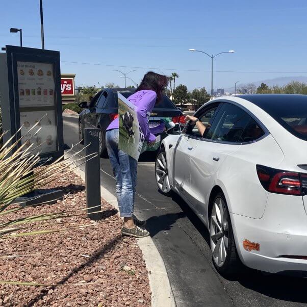 PETA activist hands out information to Starbucks customers regarding the vegan milk upcharge.