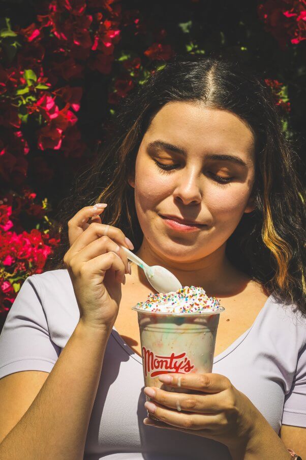 A person eating a Monty's shake with a spoon