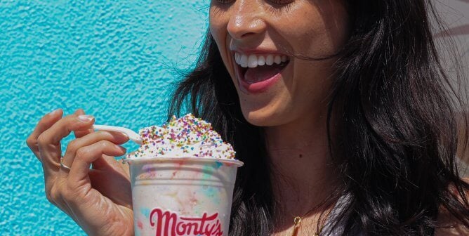 A person eating a Monty's shake with a spoon