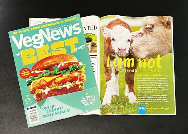 Photo of VegNews magazine flipped to full page PETA ad